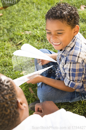 Image of Mixed Race Father and Son Playing with Paper Airplanes