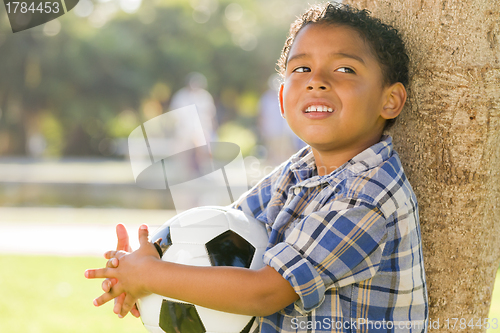 Image of Mixed Race Boy Holding Soccer Ball in the Park