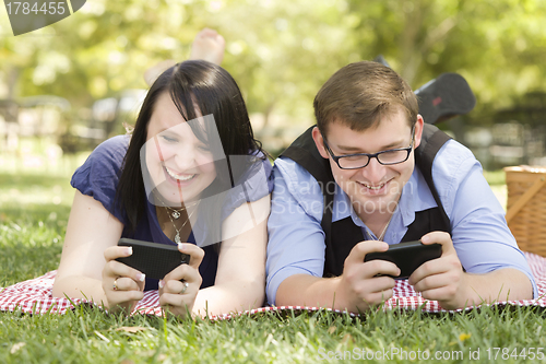 Image of Young Couple at Park Texting Together