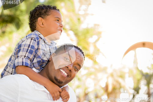 Image of Mixed Race Father and Son Playing Piggyback