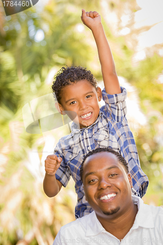 Image of Mixed Race Father and Son Cheering with Fist in Air