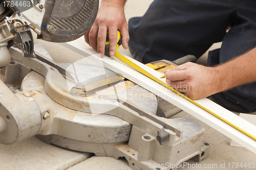 Image of Contractor Measuring for Cutting New Baseboard for Renovation