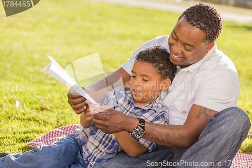 Image of Mixed Race Father and Son Playing with Paper Airplanes