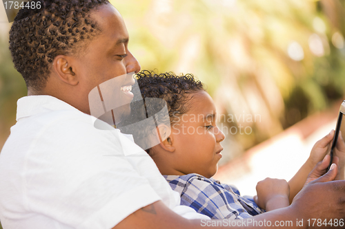 Image of Mixed Race Father and Son Using Touch Pad Computer Tablet