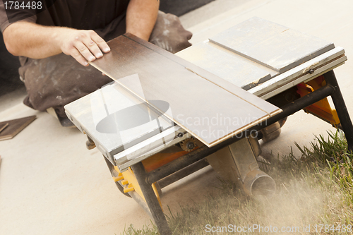 Image of Contractor Using Circular Saw Cutting of New Laminate Flooring