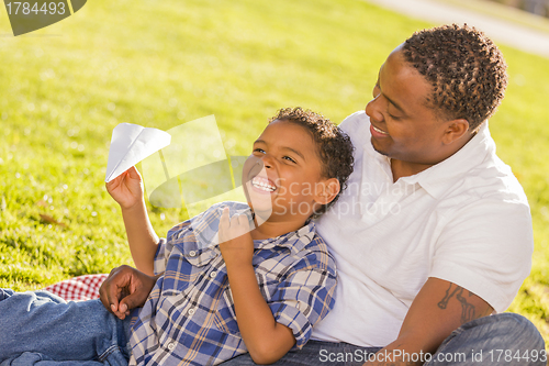 Image of Mixed Race Father and Son Playing with Paper Airplanes