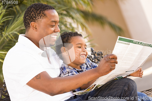 Image of Mixed Race Father and Son Reading Park Brochure Outside