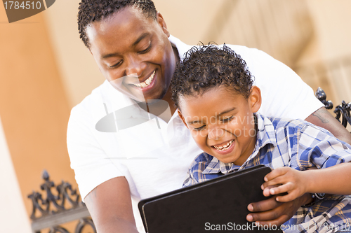 Image of Mixed Race Father and Son Using Touch Pad Computer Tablet
