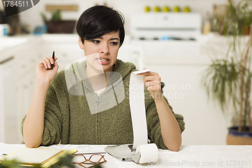 Image of Mixed Race Young Female Agonizing Over Financial Calculations