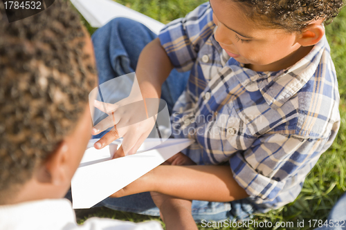 Image of Mixed Race Father and Son Playing with Paper Airplanes