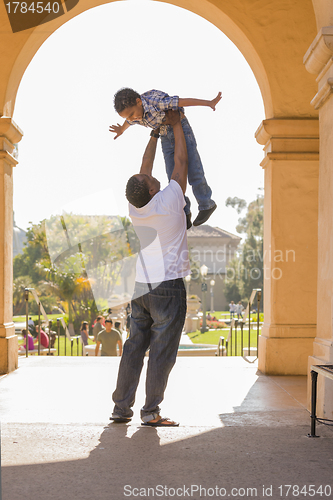Image of African American Father Lifting Mixed Race Son in the Park