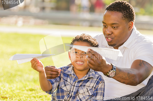 Image of Mixed Race Father and Son Playing with Paper Airplanes