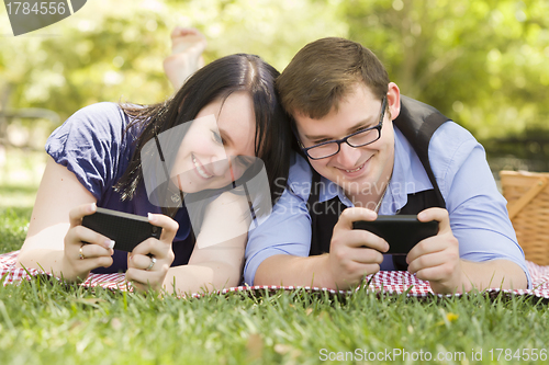Image of Young Couple at Park Texting Together