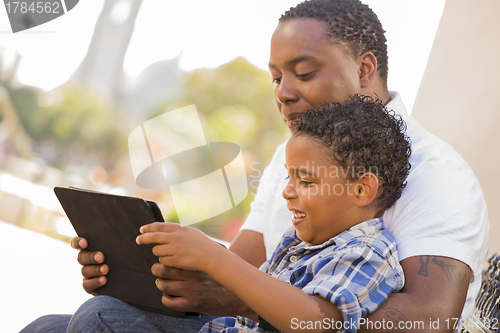 Image of Mixed Race Father and Son Using Touch Pad Computer Tablet