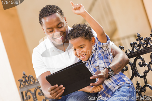 Image of Mixed Race Father and Son Using Touch Pad Computer Tablet