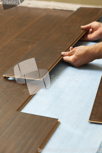 Image of Man Installing New Laminate Wood Flooring