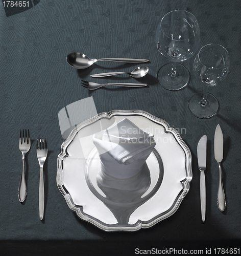 Image of exclusive place setting on dark tablecloth