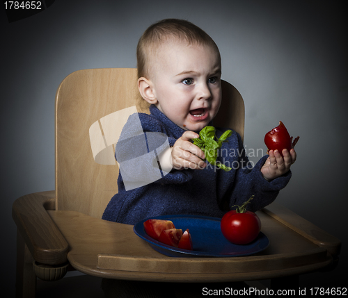 Image of young child eating in high chair