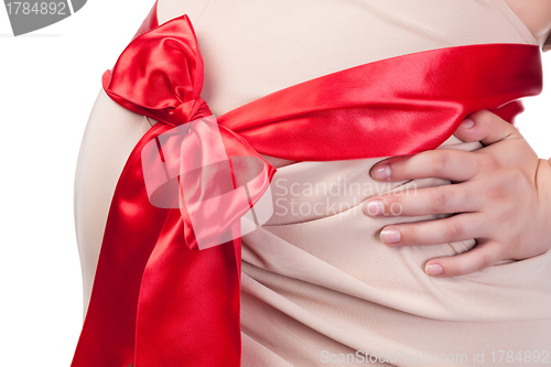 Image of Pregnant Woman's Belly with Red Ribbon