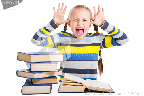 Image of schoolgirl with books putting out the tongue on isolated white