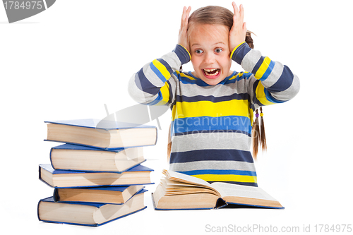 Image of schoolgirl with horror looking at pile of books on isolated white