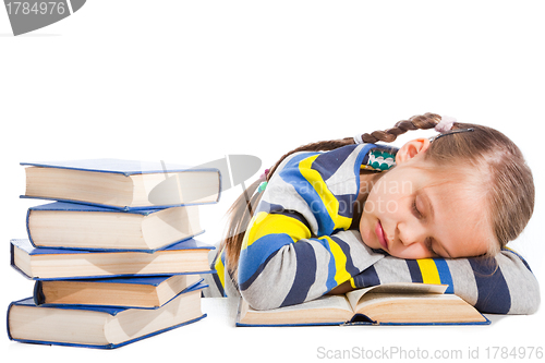 Image of schoolgirl  sleeping over the book on isolated white