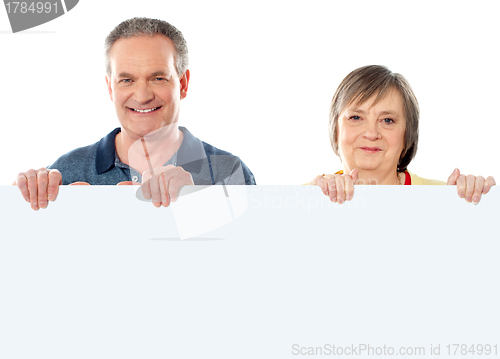 Image of Old age couple holding blank banner ad
