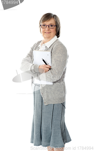 Image of Senior woman holding spiral notepad and pen