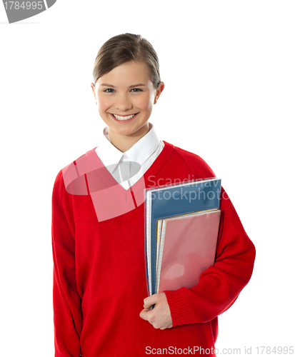 Image of Cheerful schoolgirl holding books
