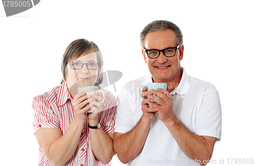 Image of Romantic senior couple holding coffee mugs