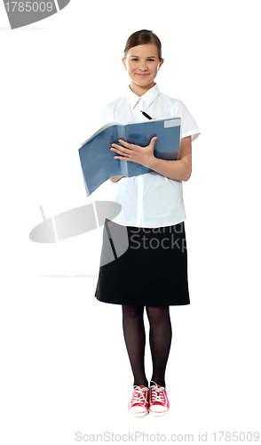Image of Full length portrait of smiling girl doing homework