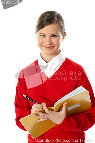 Image of Happy young girl writing on notebook