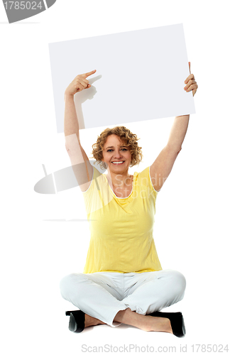 Image of Senior woman pointing at blank ad board