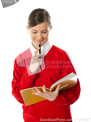 Image of Girl thinking and looking into her notebook