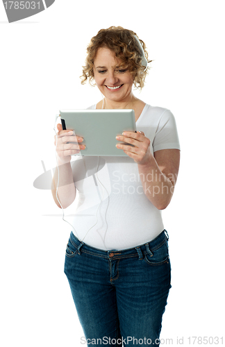 Image of Techy senior woman enjoying music