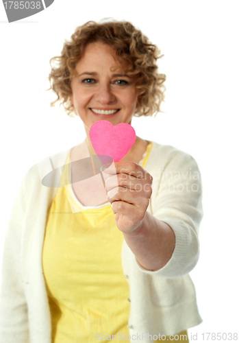 Image of Woman showing pink paper hear to camera