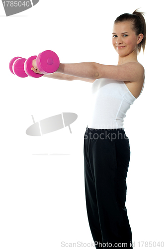 Image of Pretty teenager working out with dumbbells