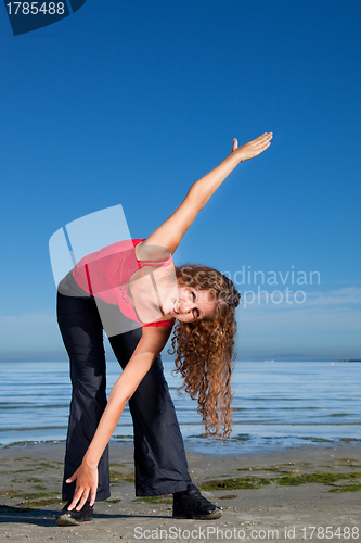 Image of girl doing morning exercises at the beach 