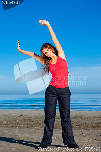 Image of girl doing morning exercises at the beach