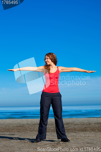 Image of girl doing morning exercises at the beach