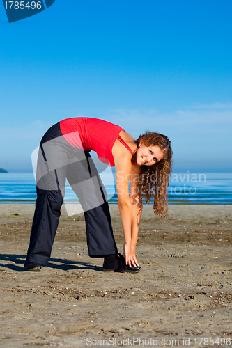 Image of girl doing morning exercises at the beach