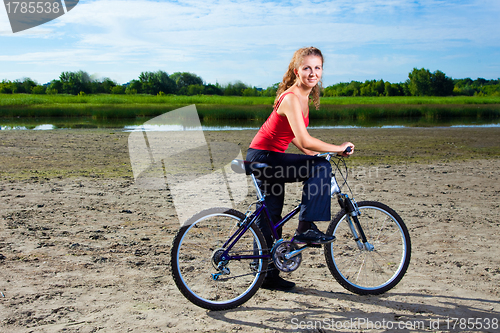 Image of beautiful woman with bicycle at the sea