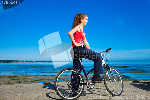 Image of beautiful woman with bicycle at the sea