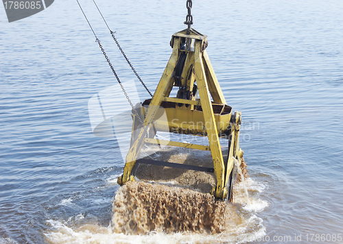 Image of Floating crane scoops soil