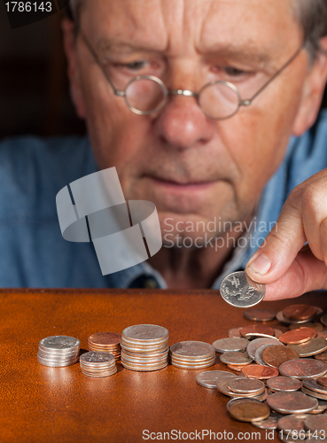 Image of Senior man counting cash into piles