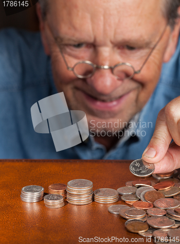 Image of Senior man counting cash into piles