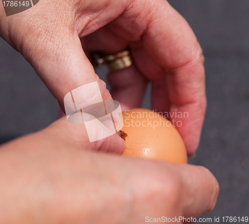 Image of Female hands cracking open egg