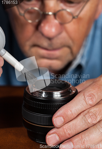 Image of Senior craftsman cleaning lens