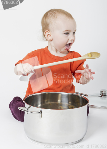 Image of baby with big cooking pot and wooden spoon