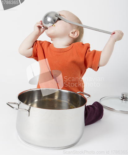 Image of baby with big cooking pot